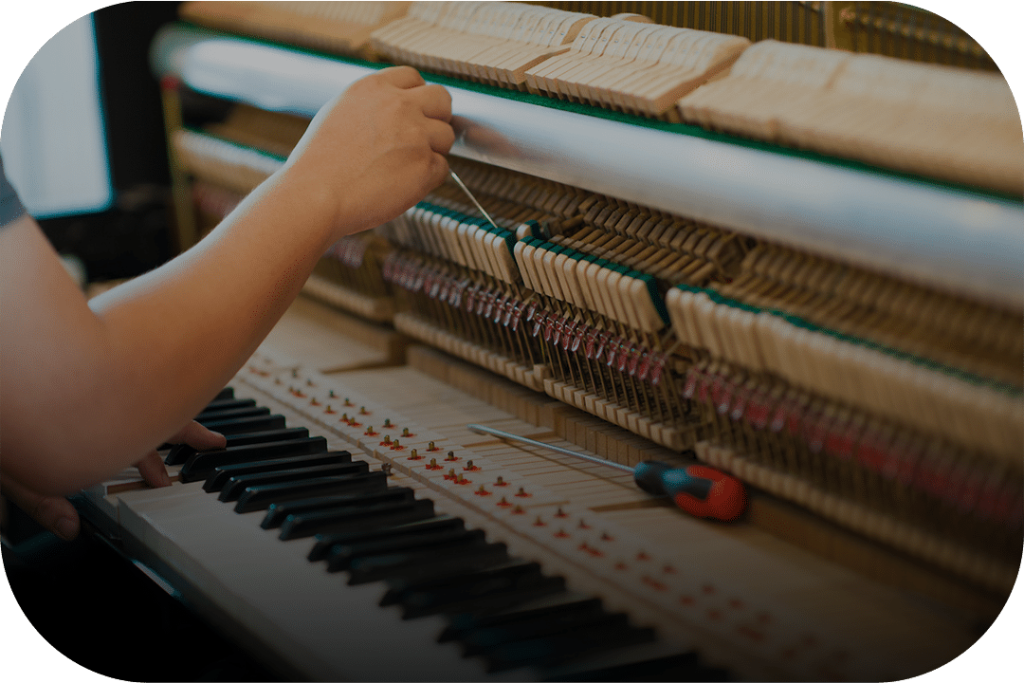 Piano tuner working on an upright piano